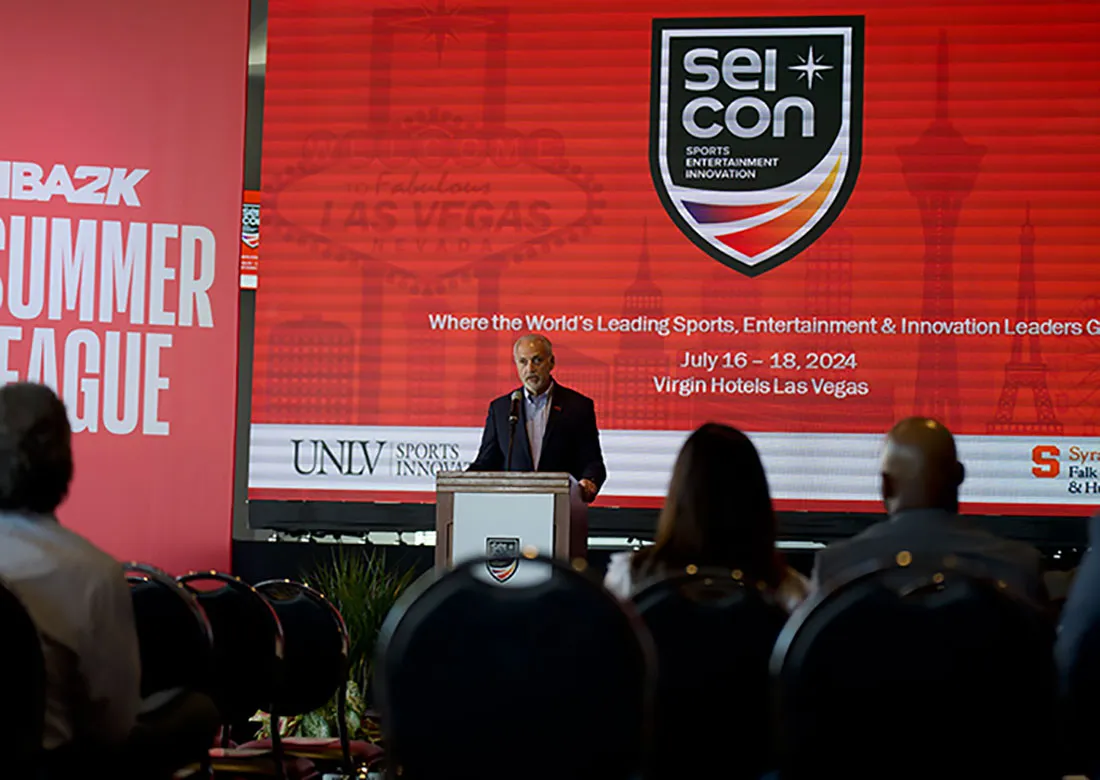 older man standing at podium
