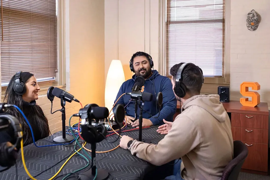 three people wearing headphones while doing a podcast