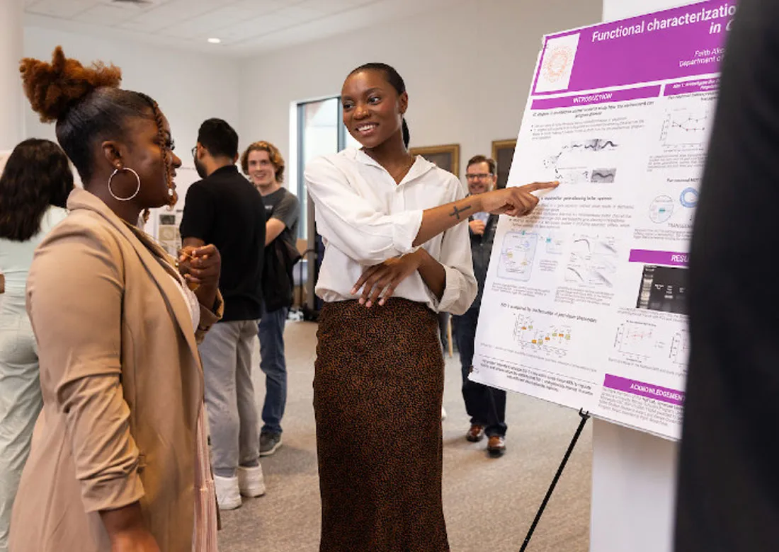 young woman presenting her poster at symposium