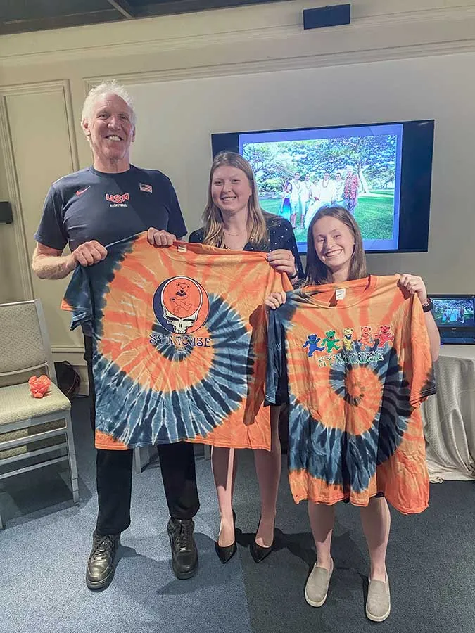 three people holding up tye dyed tshirts