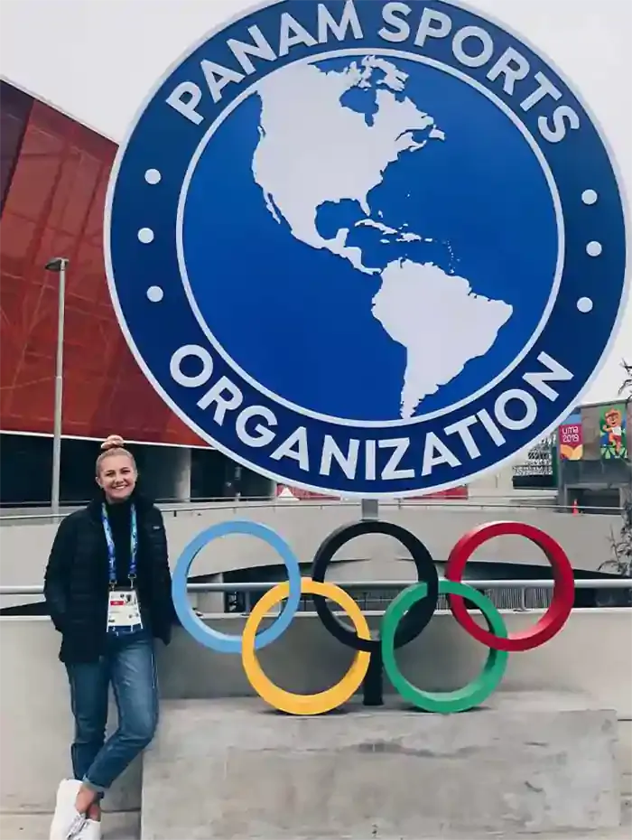 women standing next to winter Olympics symbol
