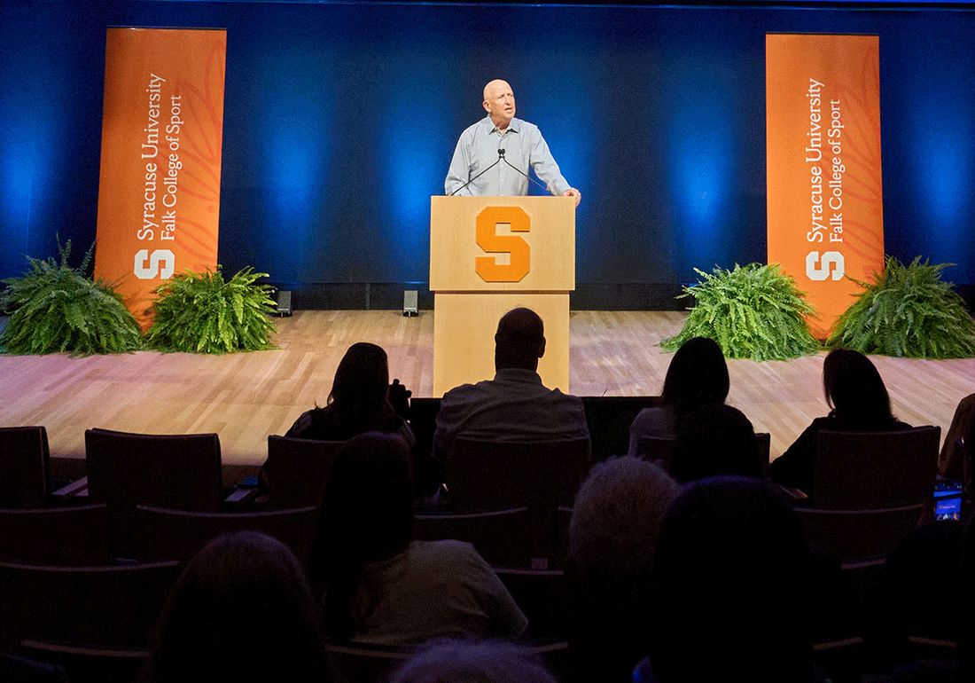 man presenting from stage in auditorium