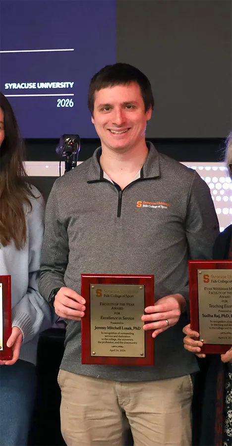 Jeremy Losak poses with his 2026 Faculty of the Year award