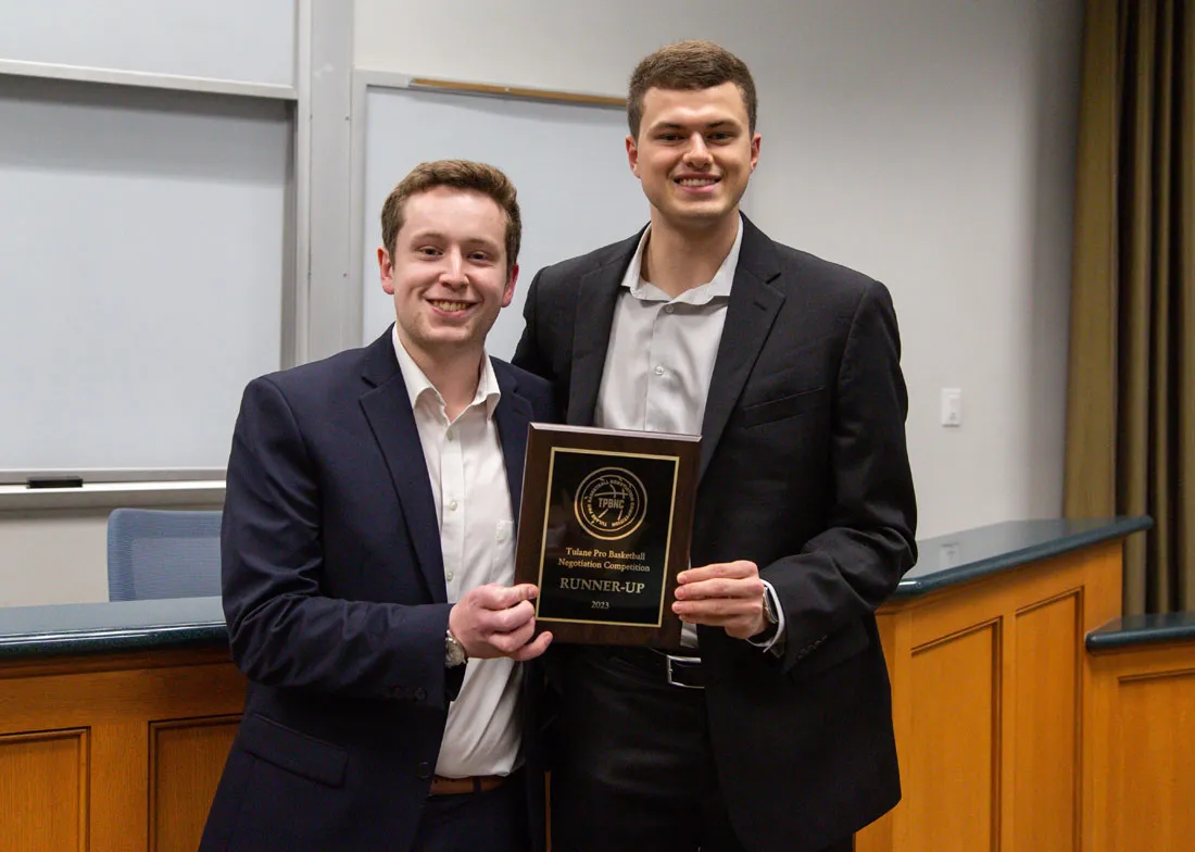 two men standing up holding an award