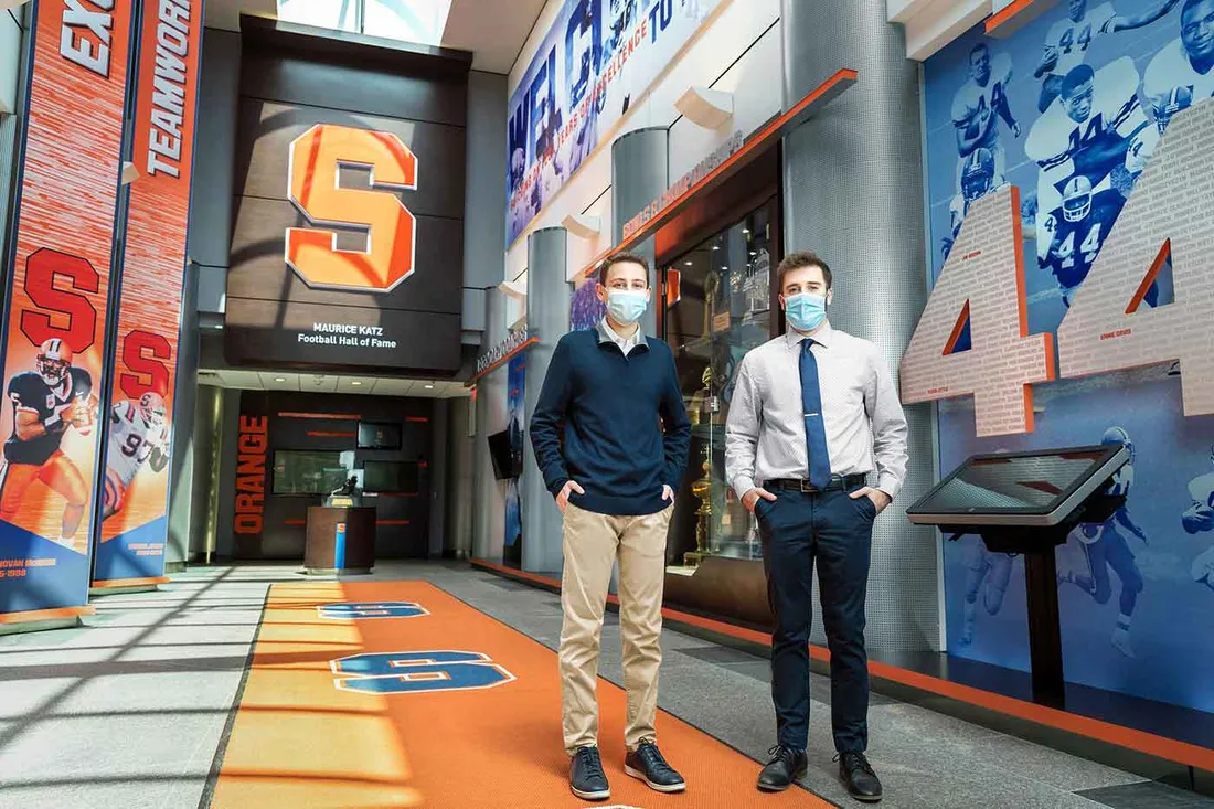 two masked male students standing in Manley Fieldhouse
