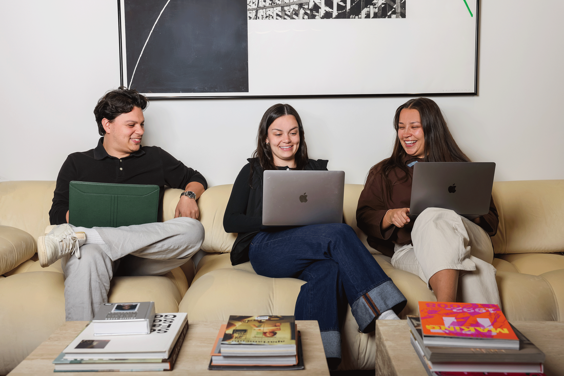 Luca Giacobbe, Elizabeth Vogt, and Caroline Johnson sit on their computers in an office space at The Montag Group.