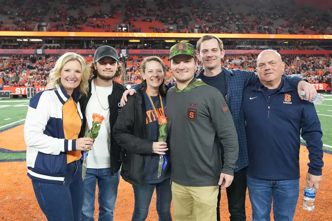 student and family standing on field of dome
