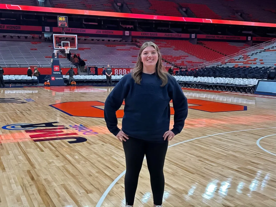 young women dressed in navy blue athletic gear standing on basketball court