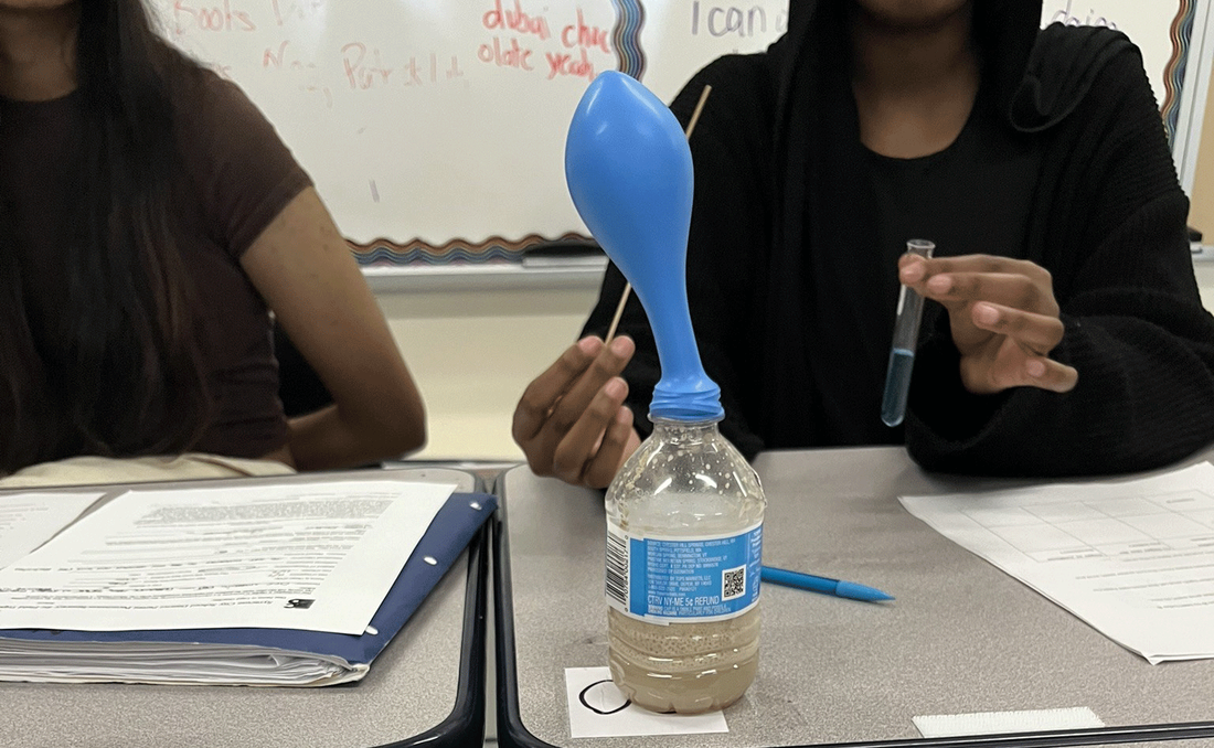 doing testing using a plastic bottle with balloon attached and fluid inside bottle