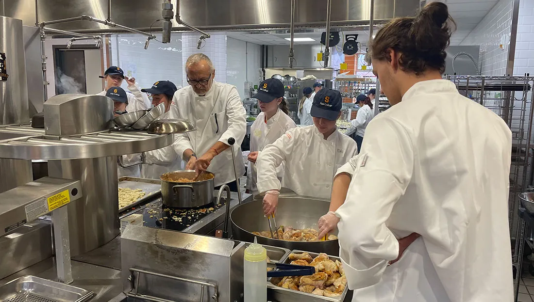 Chef working with students in kitchen