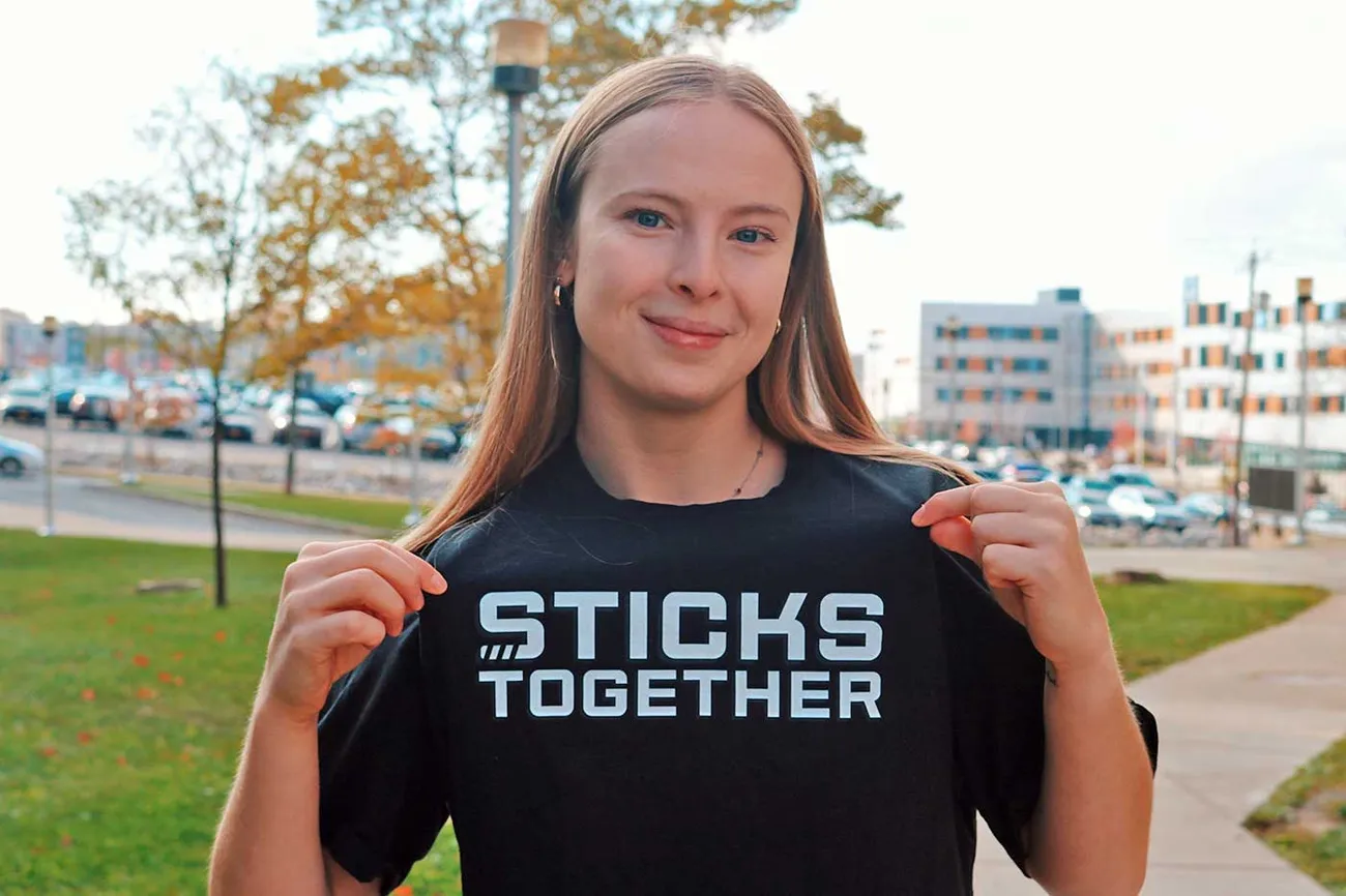 young women with long brown hair wearing tshirt that says Sticks Together