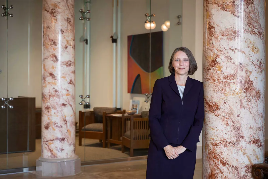 women leaning against marble pillar