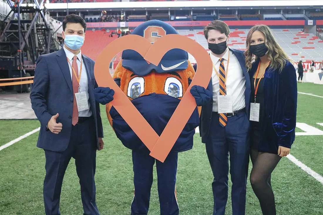 three spm students who are co-chairs for auction standing on field with otto