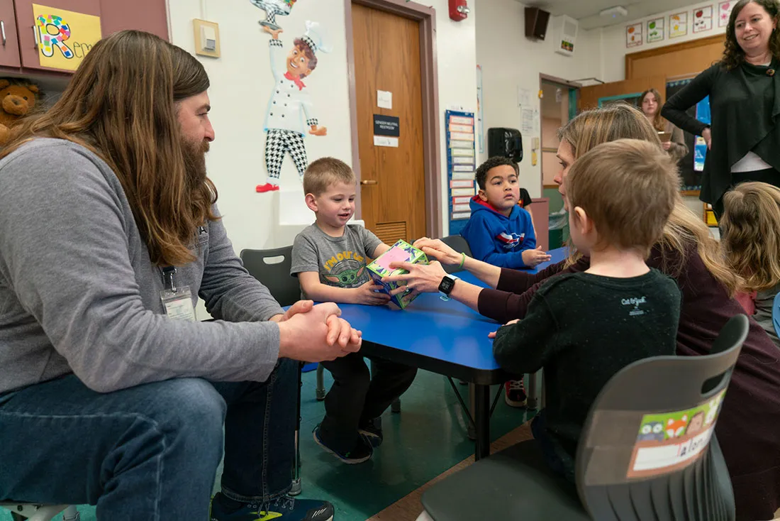 male pre-k teacher Mark sitting with children
