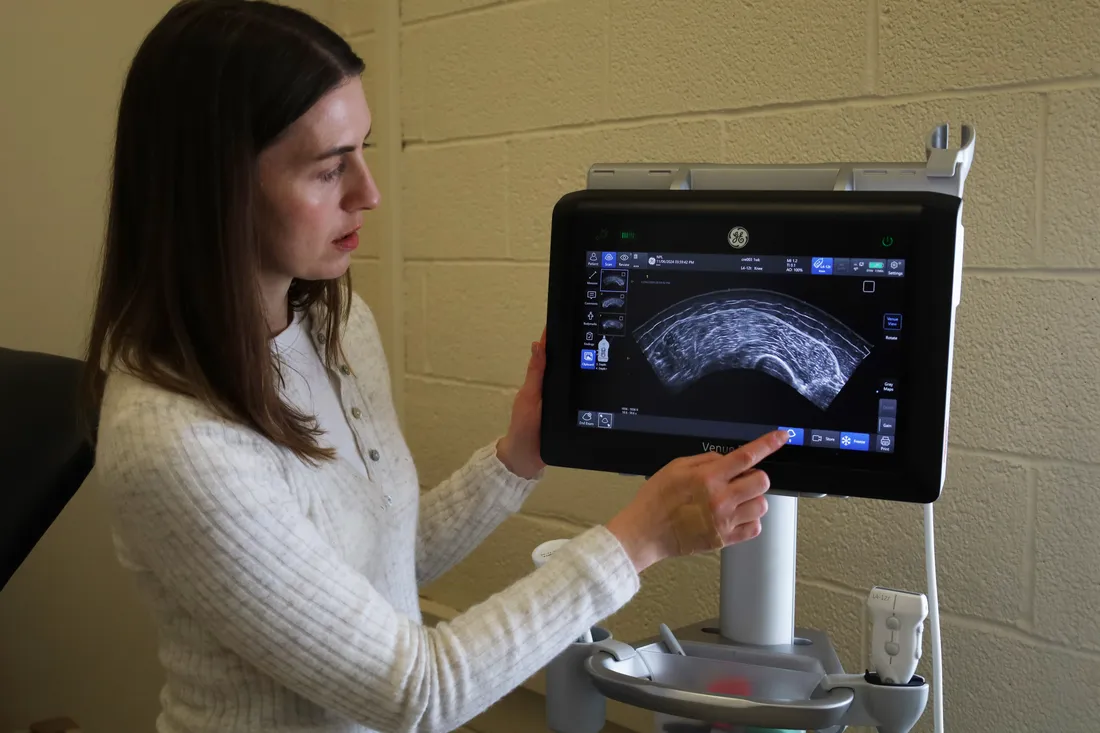 Kelly Harmon points at a research device