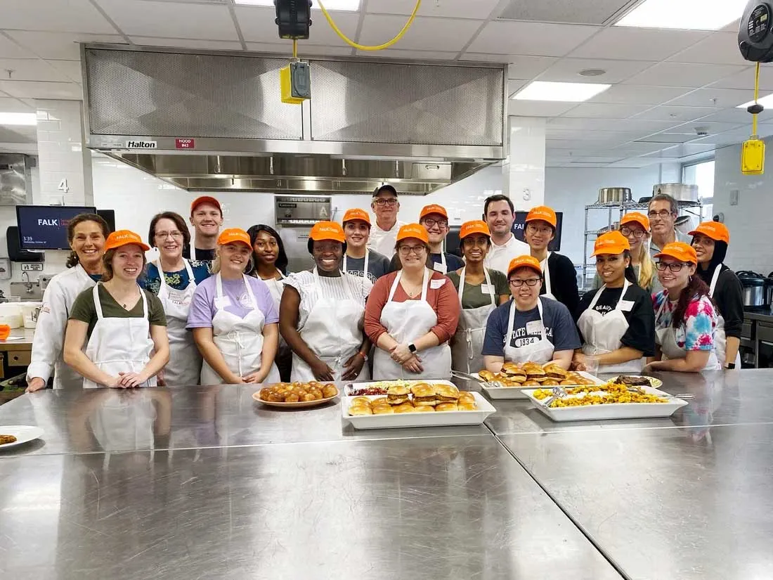 Upstate University students standing together in kitchen behind prep counter