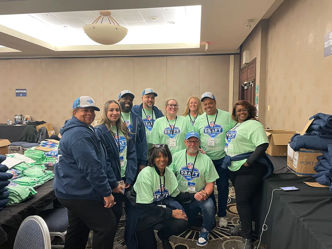 volunteers at the NFL draft standing together in a room