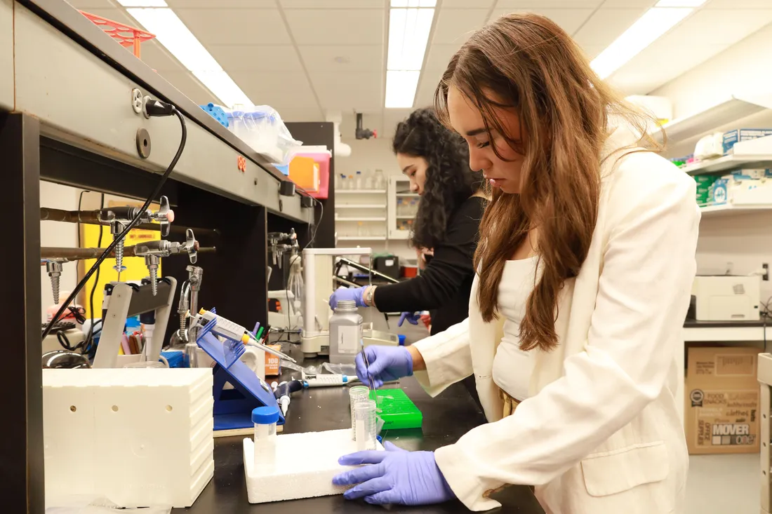 A student works with a centrifuge in a lab