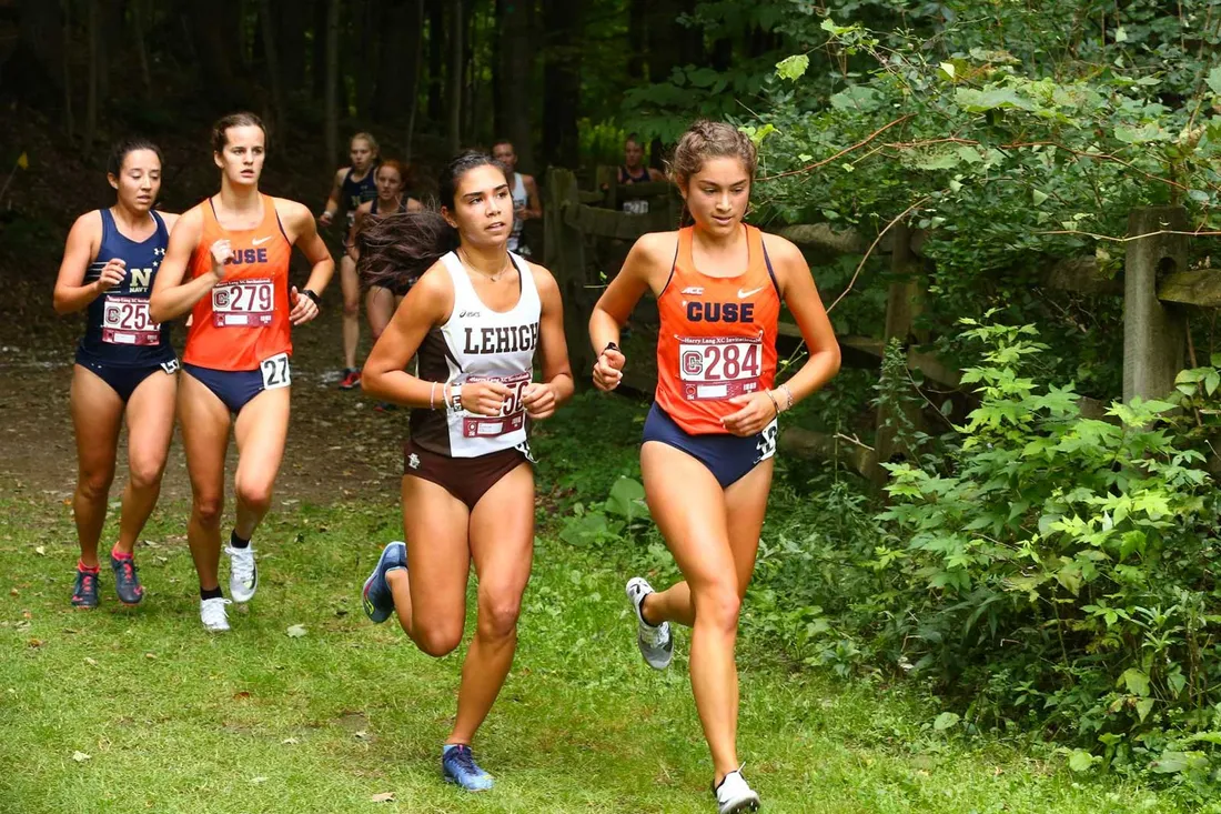 SU cross country team running through the grass and trees
