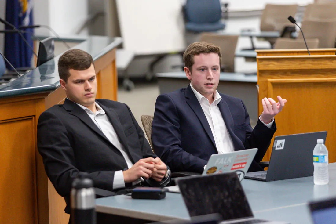 Two students sitting behind a table