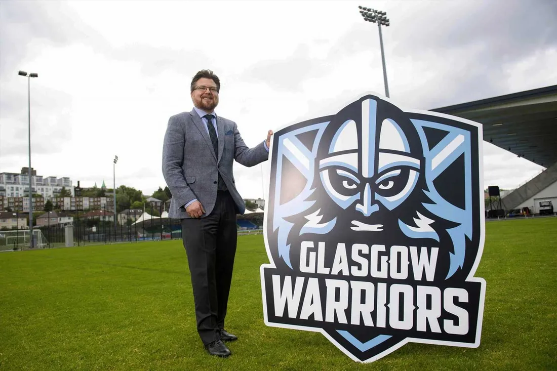 man standing next for Glasgow Warriors sign