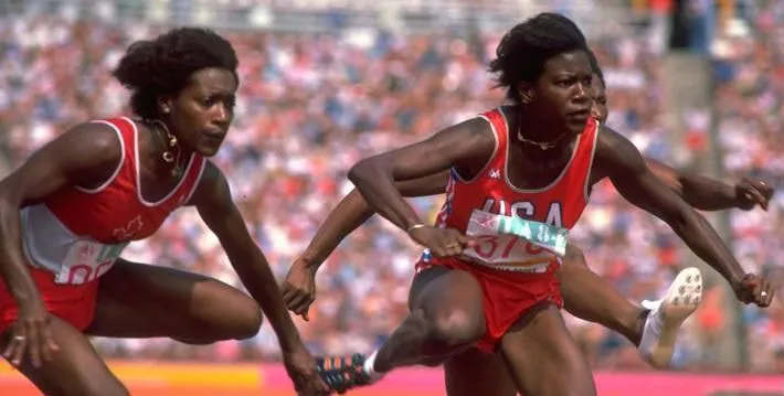 three women running and jumping hurdles